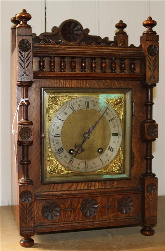 A late 19th century German carved oak and mahogany eight day striking mantel clock